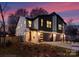 Modern two-story townhome exterior features stone accents and black garage doors at twilight at 2201 Catalina Ave, Charlotte, NC 28206