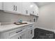 Bright laundry room with white cabinets and quartz countertops at 2201 Catalina Ave, Charlotte, NC 28206