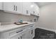 Bright laundry room with white cabinets, black hardware, and a spacious countertop at 2201 Catalina Ave, Charlotte, NC 28206