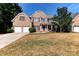 Traditional two-story brick home with a two-car garage and covered front porch at 3848 Burnage Hall Rd, Harrisburg, NC 28075