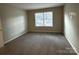 Cozy bedroom with soft carpet, neutral walls, and a large window to let the sunshine in at 6017 Treetop Ct, Charlotte, NC 28212