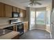 Bright kitchen with wood cabinets, black appliances, gray countertops, wood-style flooring, and a bay window at 6017 Treetop Ct, Charlotte, NC 28212