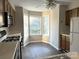 The kitchen has wood cabinets, gray countertops, black appliances, wood-style flooring, and a bay window at 6017 Treetop Ct, Charlotte, NC 28212