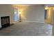 Neutral living room featuring a fireplace with a white mantle, a large window, new carpeting and neutral walls at 6017 Treetop Ct, Charlotte, NC 28212