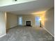 Bright living room features a fireplace, soft carpet, and a large window for ample natural light at 6017 Treetop Ct, Charlotte, NC 28212
