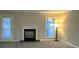 Living room with a fireplace with a white mantle, a large window, new carpeting and neutral walls at 6017 Treetop Ct, Charlotte, NC 28212