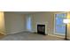 Bright living room features a fireplace, soft carpet, and a large window for ample natural light at 6017 Treetop Ct, Charlotte, NC 28212