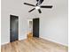 Well-lit bedroom with modern ceiling fan, two closets, wood-look floors, and neutral paint scheme at 10519 Brawley Ln, Charlotte, NC 28215