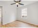Bedroom with wood-look floors, a ceiling fan, and a window overlooking a wooded area at 10519 Brawley Ln, Charlotte, NC 28215