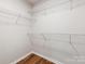 Walk-in closet with wooden floors and white wire shelving for easy organization at 10519 Brawley Ln, Charlotte, NC 28215