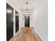 Hallway with hardwood floors leading to the front door and other rooms with black interior doors at 10519 Brawley Ln, Charlotte, NC 28215