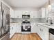 Bright kitchen featuring stainless steel appliances and white cabinets with contrasting hardware at 10519 Brawley Ln, Charlotte, NC 28215