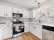 Well-lit kitchen with stainless steel appliances, modern backsplash, and white cabinetry at 10519 Brawley Ln, Charlotte, NC 28215
