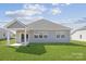 View of the backyard with a covered patio, lush green lawn, and exterior of a well-maintained home at 1133 Hallman Branch Ln, Lincolnton, NC 28092