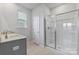 Well-lit bathroom offers granite countertop, dual sinks, and glass-enclosed shower with built in shelves at 1133 Hallman Branch Ln, Lincolnton, NC 28092