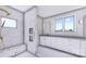 A luxurious bathroom with a glass shower enclosure, double vanity, and marble-style tile at 428 Dover Ave, Charlotte, NC 28209