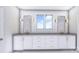 Bathroom with white cabinets, double vanity with mirrors, and a window at 428 Dover Ave, Charlotte, NC 28209