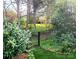 Private backyard with black fence, lawn, mature trees, and lush landscaping for a serene outdoor space at 13112 Appolinaire Dr, Davidson, NC 28036