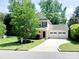 Beautiful two-story home with an attached two-car garage, lush landscaping, and a welcoming front entrance at 13112 Appolinaire Dr, Davidson, NC 28036