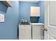 Bright laundry room with washer, dryer, and overhead cabinets at 20109 Norman Colony Rd, Cornelius, NC 28031