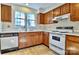 Kitchen with wood cabinets, white appliances, and vinyl flooring at 6125 Gray Gate Ln # F, Charlotte, NC 28210