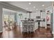 Open kitchen with island seating, stainless appliances, and adjacent dining area with natural light at 7520 Berkeley W Rd, Denver, NC 28037