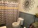 Well-maintained bathroom featuring a toilet with an elevated seat, patterned shower curtain, and decorative mirror at 941 10Th St # 3, Lancaster, SC 29720