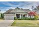 Tan two-story house with a two-car garage, manicured lawn, and landscaping at 1035 Crescent Moon Dr, Fort Mill, SC 29715