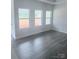 Bright and airy living room with grey vinyl flooring and large windows at 1054 Bull Dog Ln, Wingate, NC 28174
