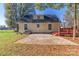 Yellow home's backyard features a concrete patio, a red deck, and a serene outdoor setting at 2216 Lowell Bethesda Rd, Gastonia, NC 28056