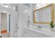 Bright bathroom featuring a white vanity, decorative mirror and a combination shower and tub at 2216 Lowell Bethesda Rd, Gastonia, NC 28056