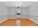 Open dining room with traditional chandelier, chair rail, glossy hardwood floors, and view of backyard at 2216 Lowell Bethesda Rd, Gastonia, NC 28056