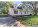 Inviting yellow home featuring red shutters, a cozy front porch, and a convenient driveway at 2216 Lowell Bethesda Rd, Gastonia, NC 28056