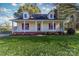 A cozy yellow house boasts a welcoming front porch, red shutters, and a well-manicured lawn at 2216 Lowell Bethesda Rd, Gastonia, NC 28056