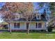 Charming yellow home with dormer windows, brick foundation and front porch with red shutters at 2216 Lowell Bethesda Rd, Gastonia, NC 28056