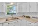 Charming kitchen with white cabinets, subway tile backsplash, stainless steel sink, and marble countertops at 2216 Lowell Bethesda Rd, Gastonia, NC 28056