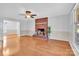 Spacious living room with brick fireplace, fan, neutral paint, and glossy hardwood floors at 2216 Lowell Bethesda Rd, Gastonia, NC 28056