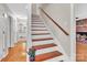 Bright, inviting staircase featuring hardwood steps and railing, complemented by natural light from nearby rooms at 2216 Lowell Bethesda Rd, Gastonia, NC 28056