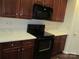 A view of the oven and overhead microwave with white countertops and wooden cabinets at 284 Garnet Ct, Fort Mill, SC 29708