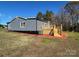 Back view of home with wooden porch, new siding, white windows, and green grass at 3596 Bethany Church Rd, Claremont, NC 28610