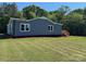Back view of home with wooden porch, new siding, white windows, and green grass at 3596 Bethany Church Rd, Claremont, NC 28610