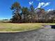 View of the driveway leading to a well-maintained property surrounded by lush trees and greenery at 3596 Bethany Church Rd, Claremont, NC 28610