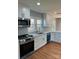 Bright kitchen features stainless appliances, white cabinets, and hardwood floors at 3596 Bethany Church Rd, Claremont, NC 28610