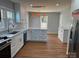 Spacious kitchen with white cabinets, granite counters, hardwood floors, and eat-in area at 3596 Bethany Church Rd, Claremont, NC 28610