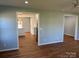 Open-concept living room with wood flooring, flowing into an eat-in kitchen with white cabinets at 3596 Bethany Church Rd, Claremont, NC 28610