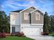 Two-story house with gray and white siding, two-car garage, and landscaped yard at 4011 Bufflehead Dr, Charlotte, NC 28269