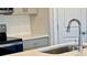 Close-up of kitchen featuring stainless steel appliances, quartz countertops, tile backsplash, and gray cabinets at 4019 Bufflehead Dr, Charlotte, NC 28269