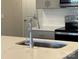 Close-up of kitchen featuring stainless steel appliances, quartz countertops, tile backsplash, and gray cabinets at 4019 Bufflehead Dr, Charlotte, NC 28269