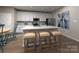 Modern kitchen with white cabinets, stainless steel appliances, tile backsplash, an island, and seating for three at 4019 Bufflehead Dr, Charlotte, NC 28269