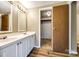 Bathroom featuring double sinks with wood-look laminate floors and closet entrance at 5320 Liberty Hill W Rd, York, SC 29745